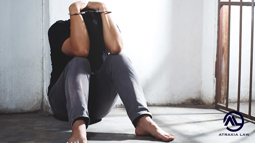 Person in handcuffs sitting on the floor